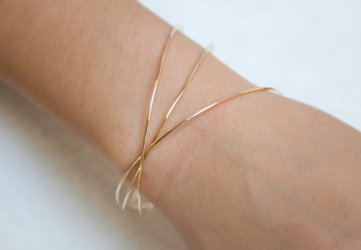 Drei ineinandergreifende vergoldete Armreifen – Eleganz im minimalistischen Design