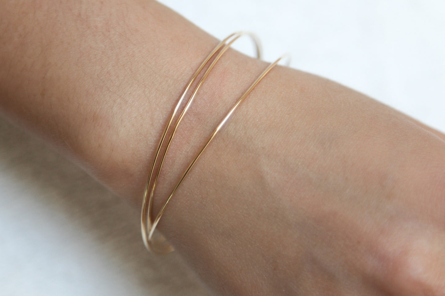 Drei ineinandergreifende vergoldete Armreifen – Eleganz im minimalistischen Design