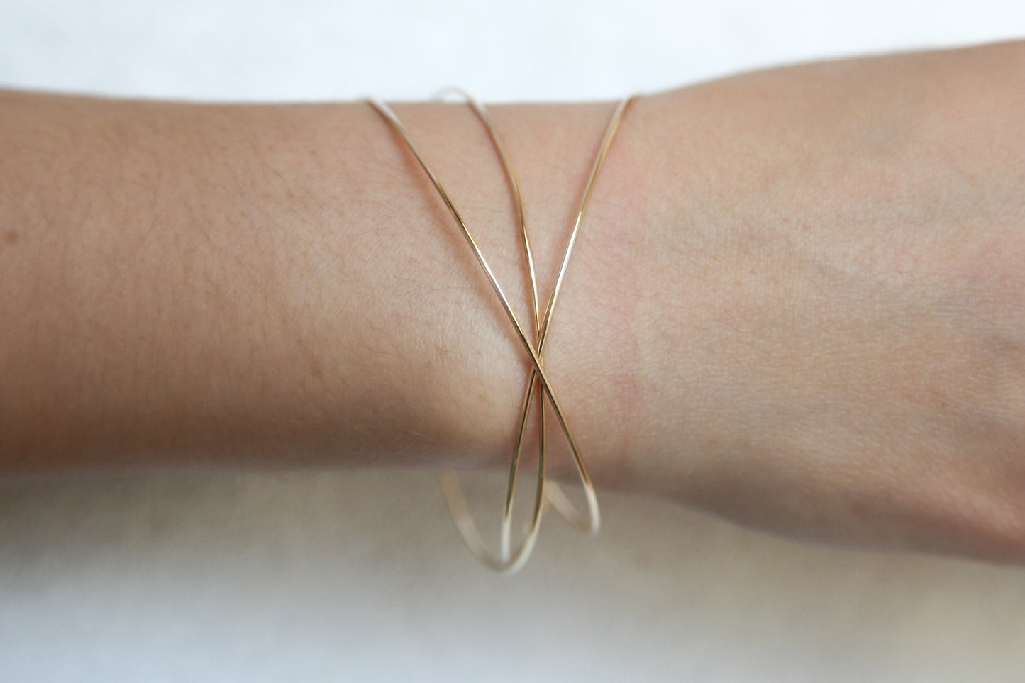 Drei ineinandergreifende vergoldete Armreifen – Eleganz im minimalistischen Design