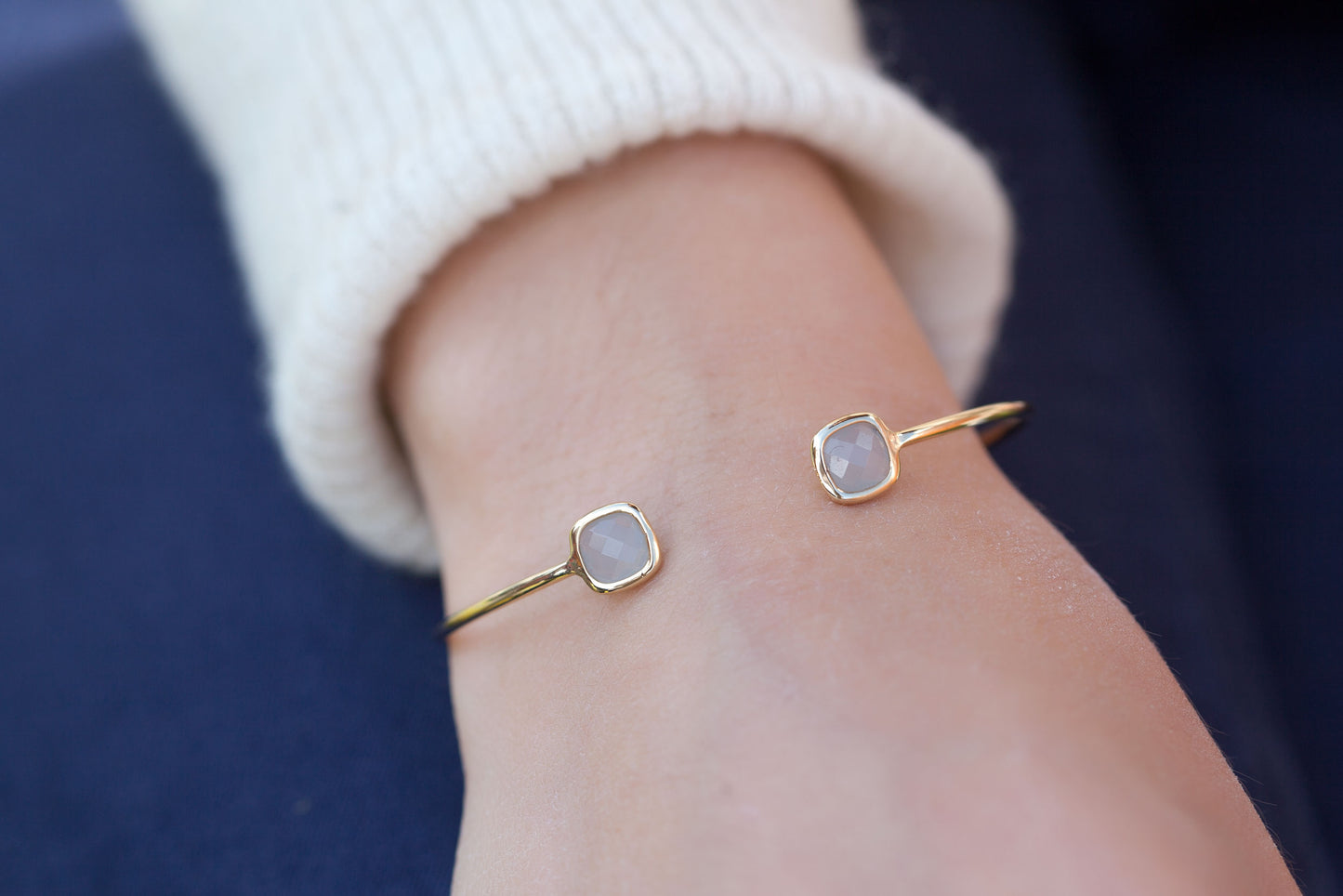 Armreif mit graufarbenen Steinen vergoldet