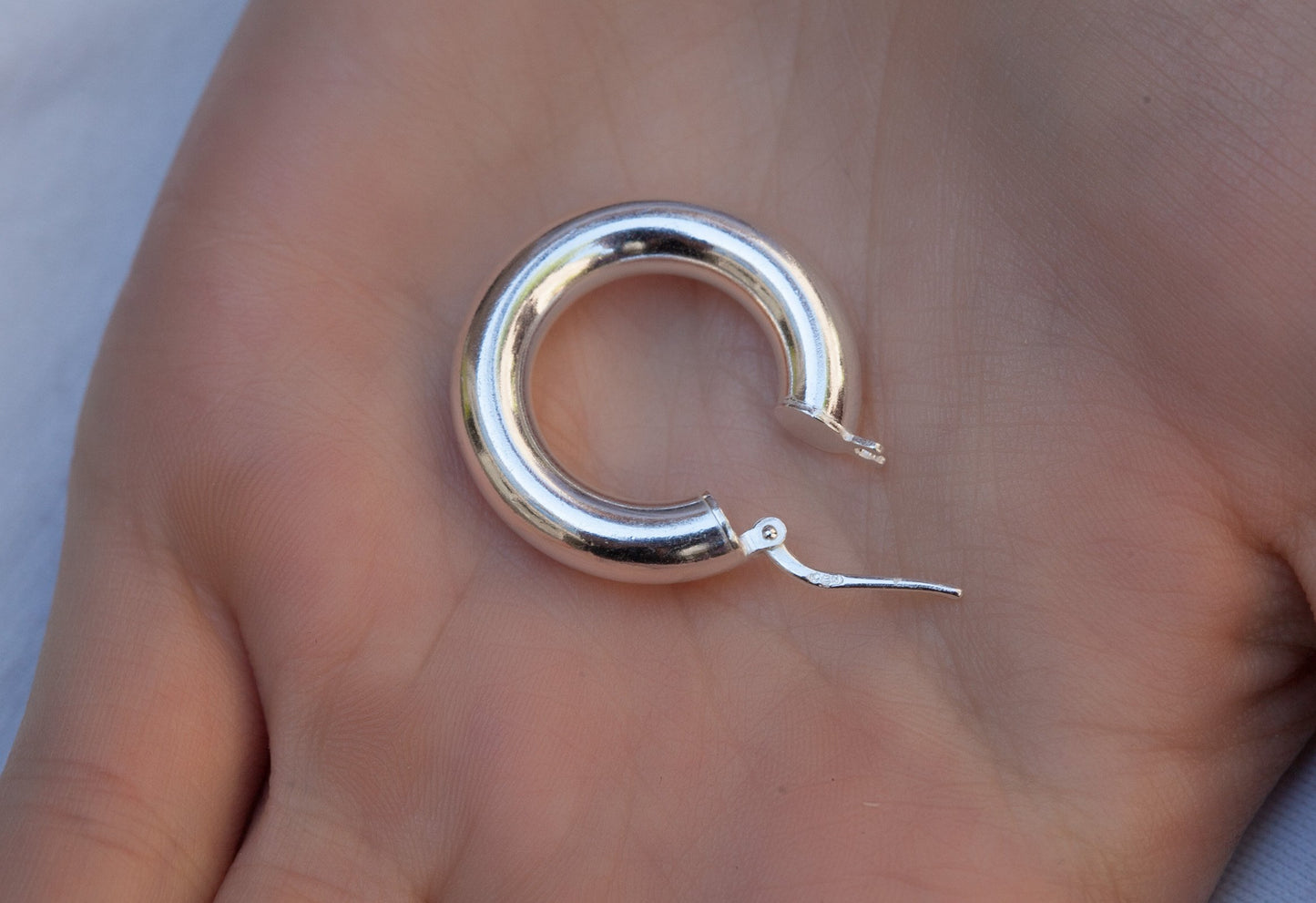 Creole aus 925er Silber in der Hand gehalten – Größenvergleich